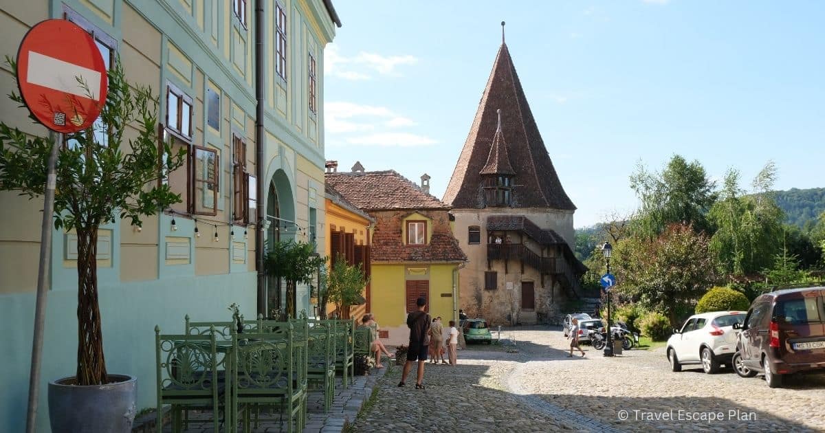 view of the medieval Bootmakers Tower at the end of a street in Sighisoara, Romania