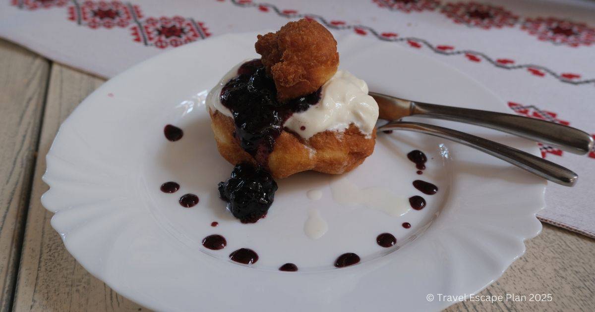 plate of romanian donuts with jam and cream