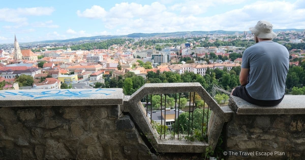 a tourist looking at Cluj-Napoca city panorama from the the Cetatuia Park viewpoint 