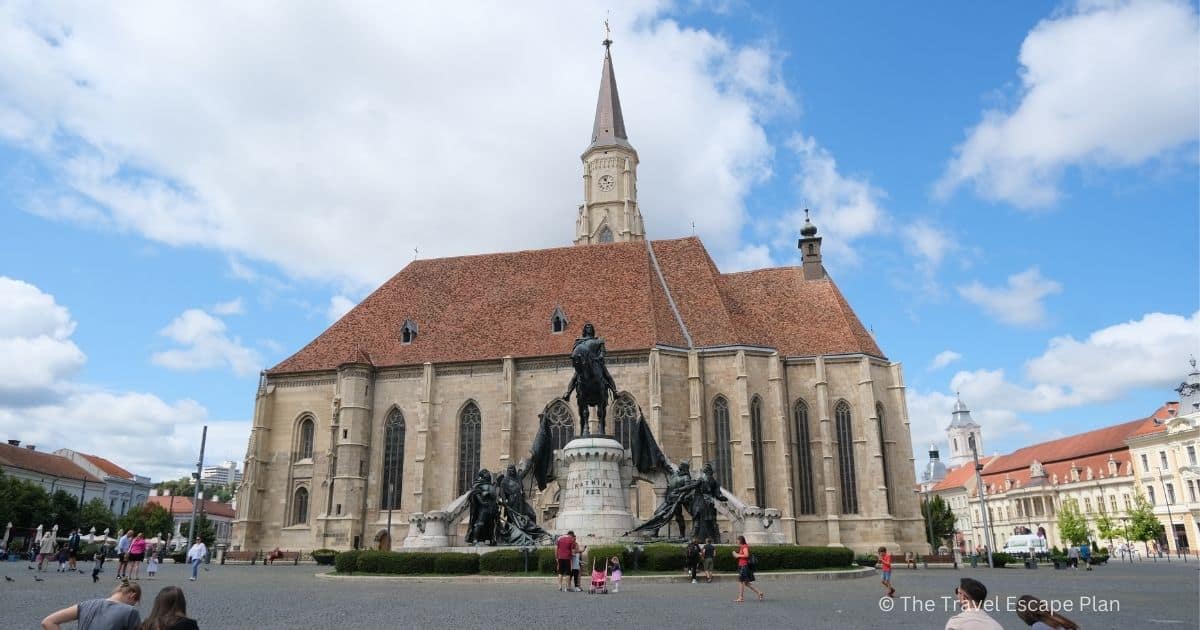 St Michael's Church with a tall spire and Matthew Corvin statue in main square of Cluj-Napoca, Romania
