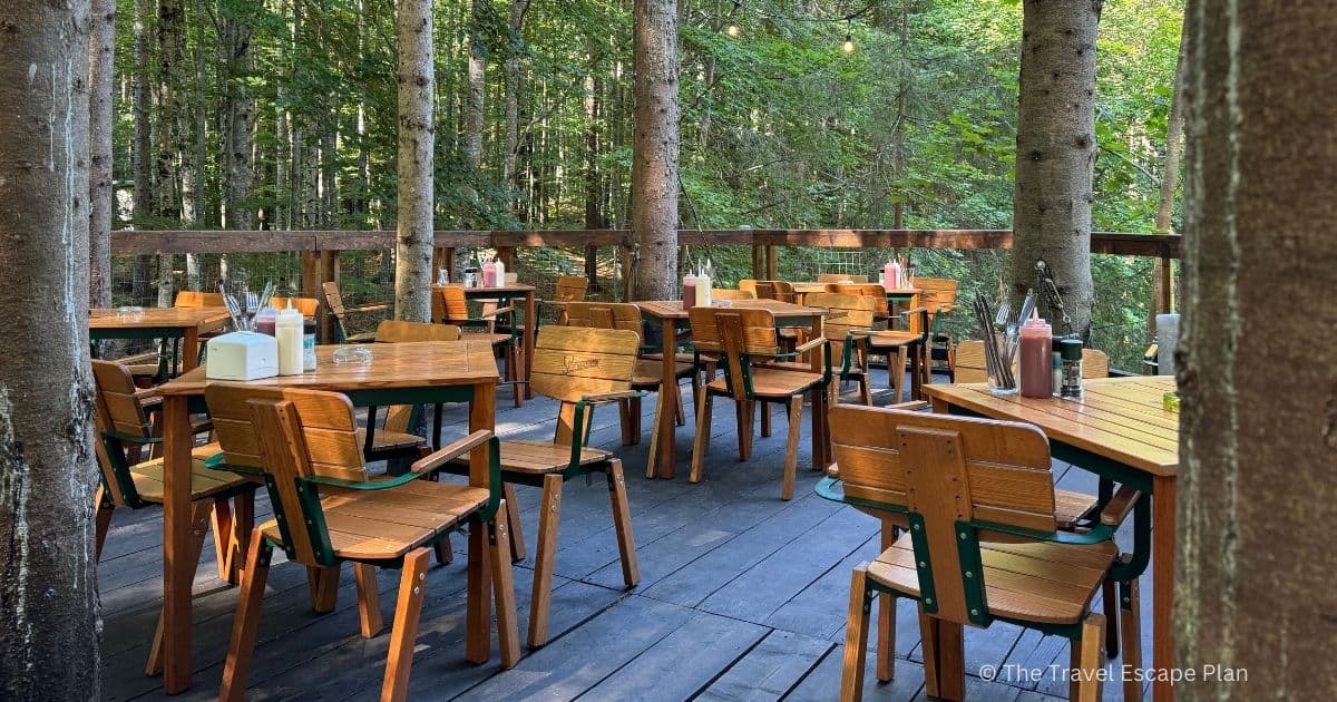 wooden chairs and tables on a wooden terrace at the Transfagarasan Tree House Village in the middle of a forest, Romania